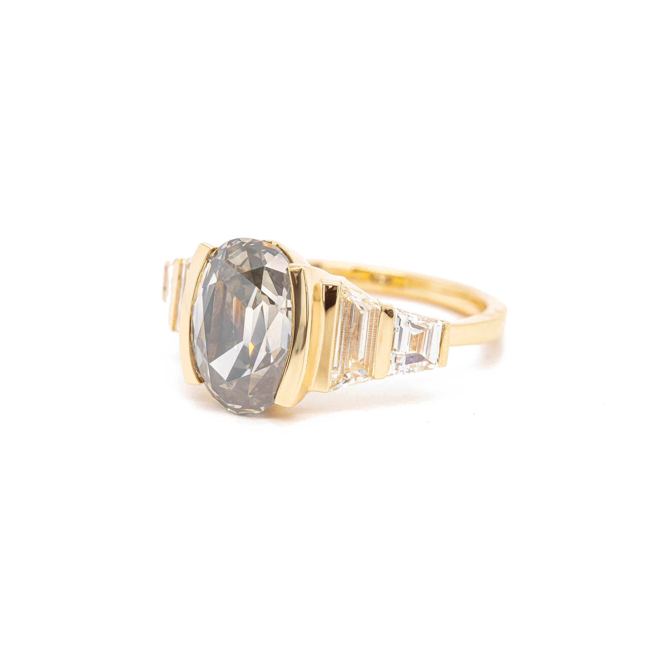 A yellow gold ring with The Phantom grey diamond and Rebecca Overmann baguette diamonds.