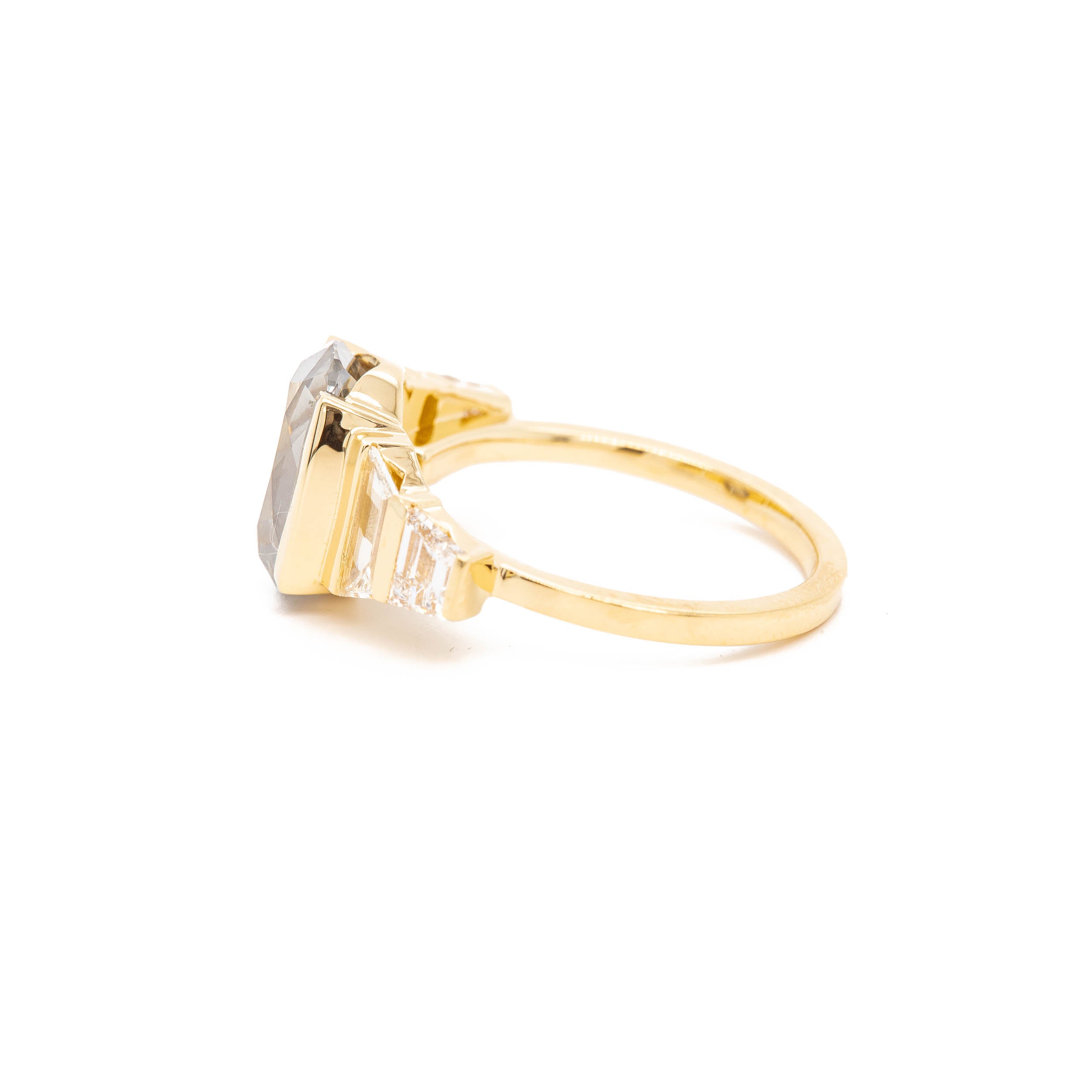 A yellow gold ring with a grey stone and diamonds, The Phantom by Rebecca Overmann.
