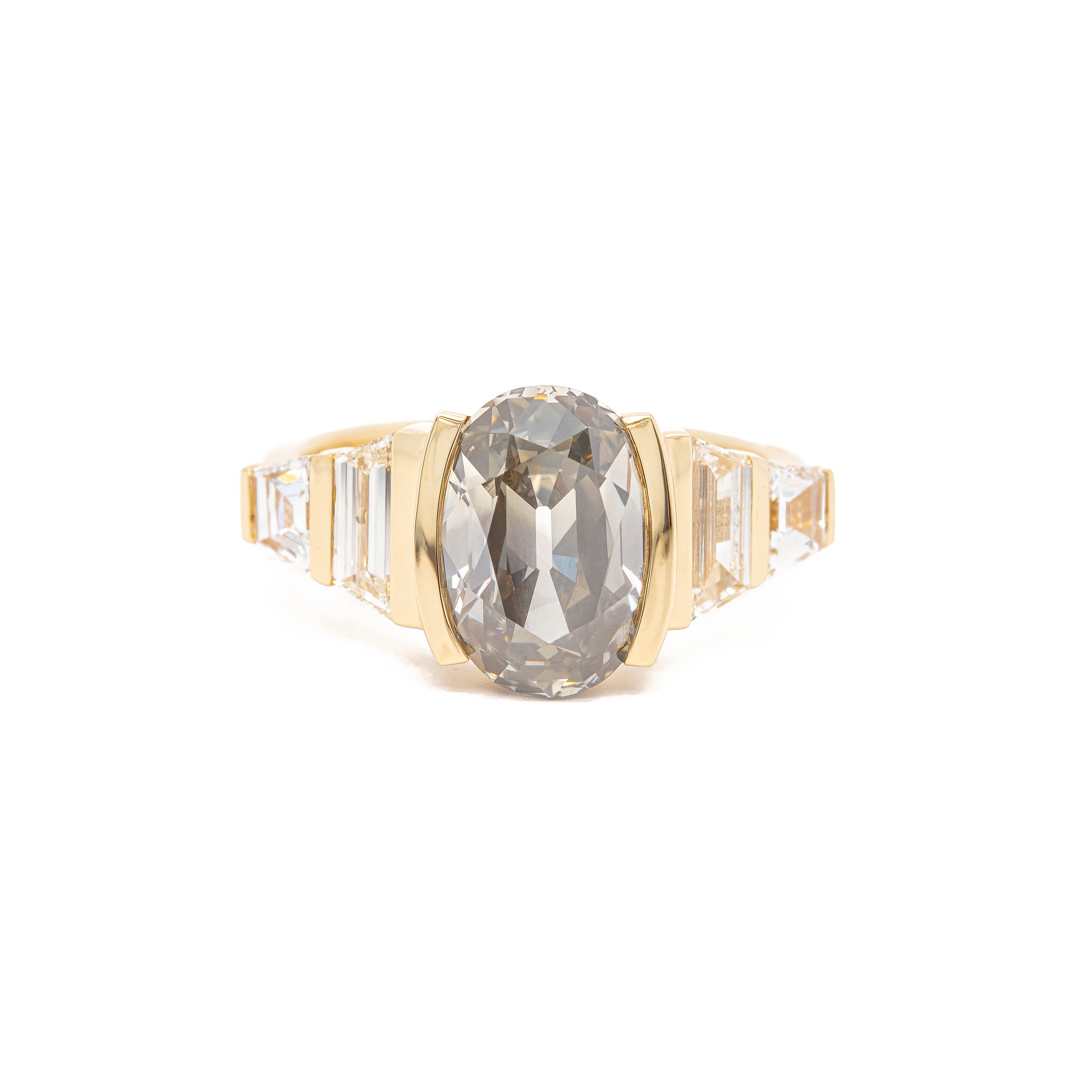 A yellow gold ring with The Phantom grey diamond and baguette diamonds, designed by Rebecca Overmann.